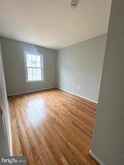 empty room with baseboards and wood finished floors