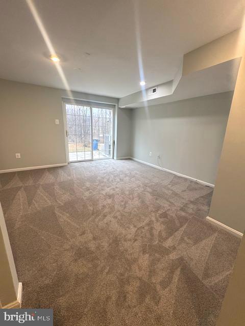 carpeted spare room with baseboards and visible vents