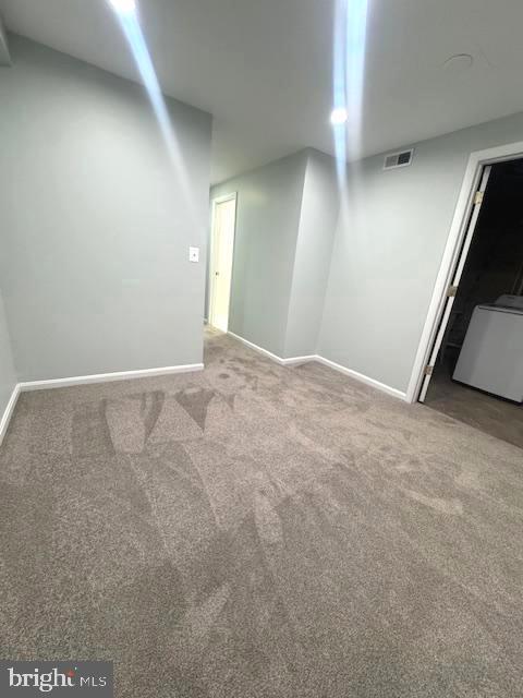 basement with carpet flooring, visible vents, and baseboards