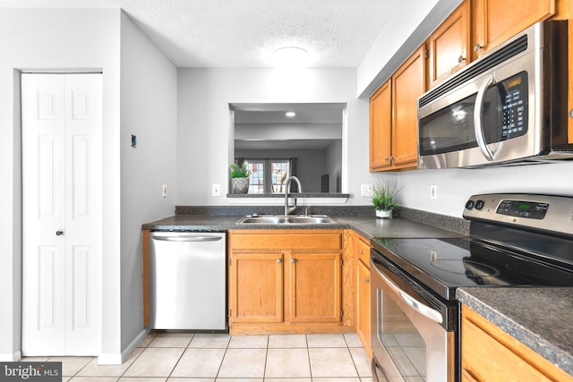 kitchen with dark countertops, stainless steel appliances, and a sink