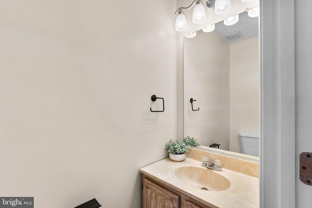 bathroom with visible vents, toilet, and vanity