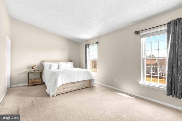 bedroom featuring lofted ceiling, baseboards, and carpet floors