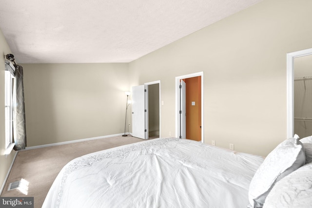 carpeted bedroom featuring visible vents, baseboards, and a textured ceiling