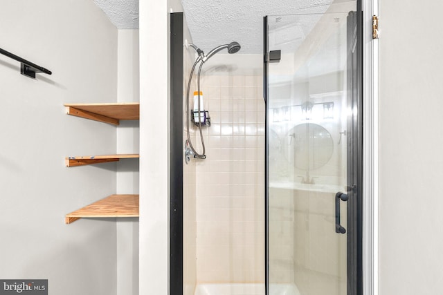 full bathroom with a stall shower and a textured ceiling