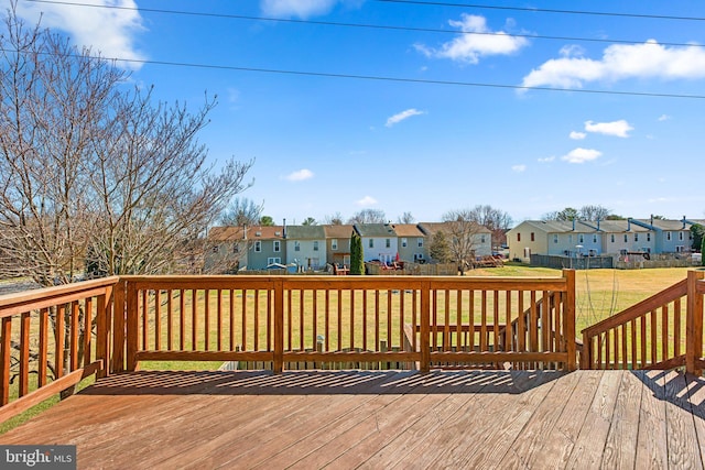 wooden terrace with a residential view and a lawn