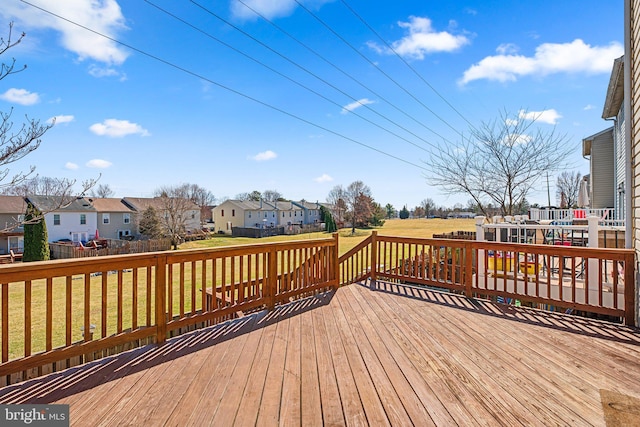 wooden deck featuring a residential view and a lawn