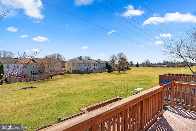 view of yard with a deck, fence, and a residential view