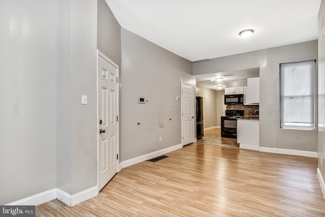 interior space with visible vents, light wood-style flooring, and baseboards