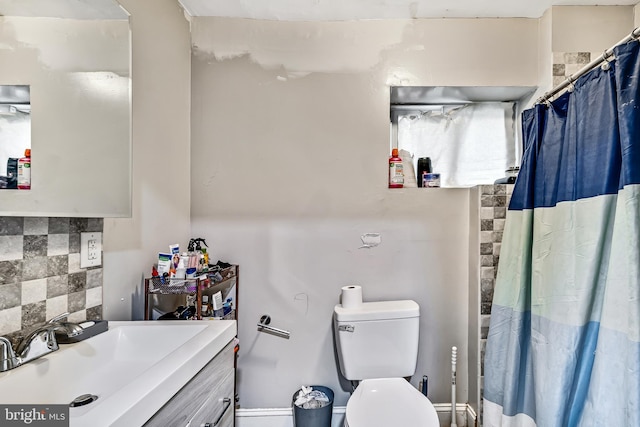 full bath with toilet, a shower with curtain, backsplash, and vanity