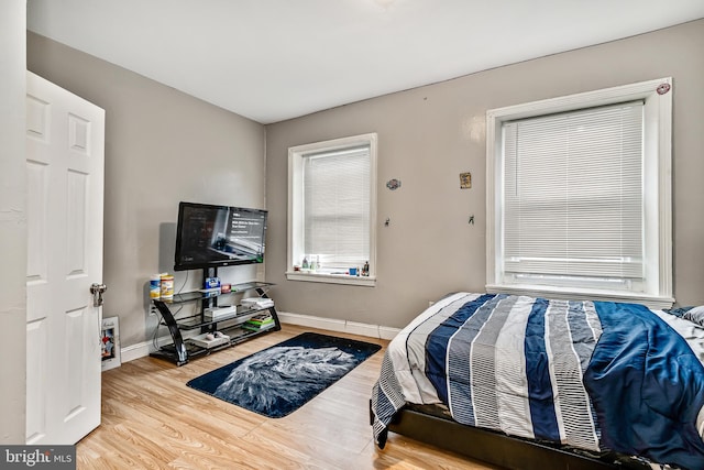 bedroom featuring baseboards and wood finished floors