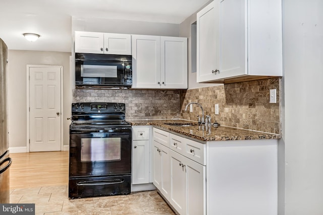 kitchen with a sink, white cabinets, decorative backsplash, black appliances, and dark stone countertops