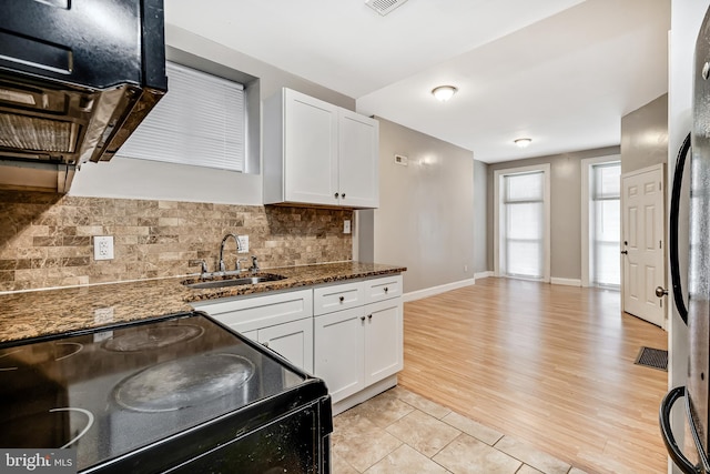 kitchen featuring black electric range, white cabinetry, a sink, and decorative backsplash