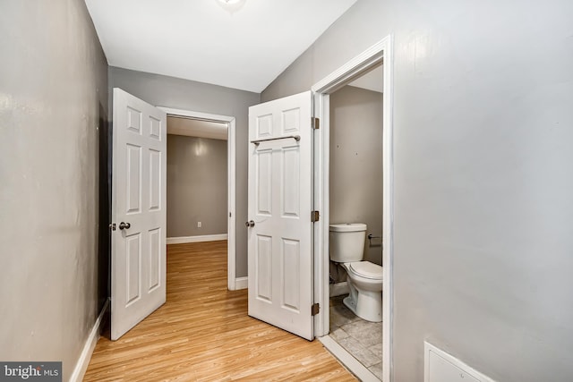 bathroom with wood finished floors, toilet, and baseboards