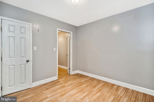 unfurnished room with light wood-style flooring and baseboards