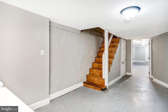 finished basement featuring stairs and baseboards