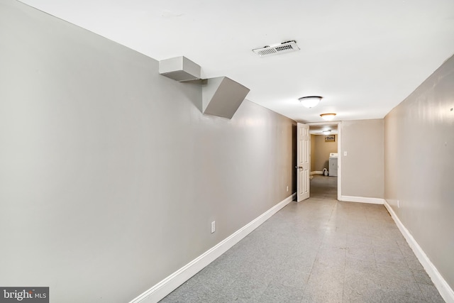 finished basement featuring light floors, baseboards, and visible vents