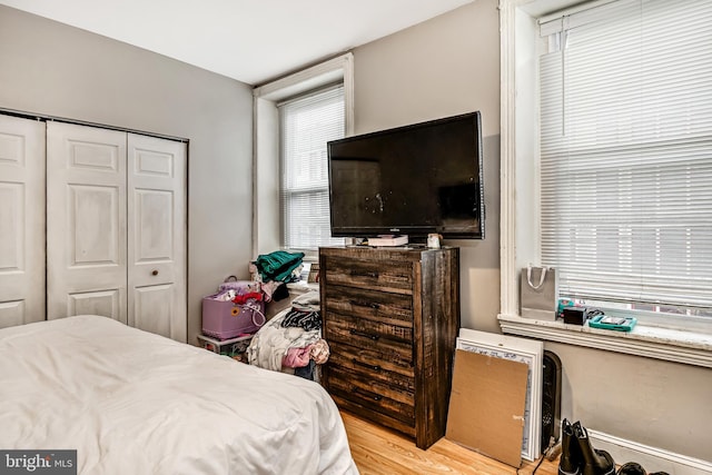 bedroom with light wood finished floors and a closet