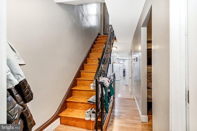 staircase with baseboards and wood finished floors