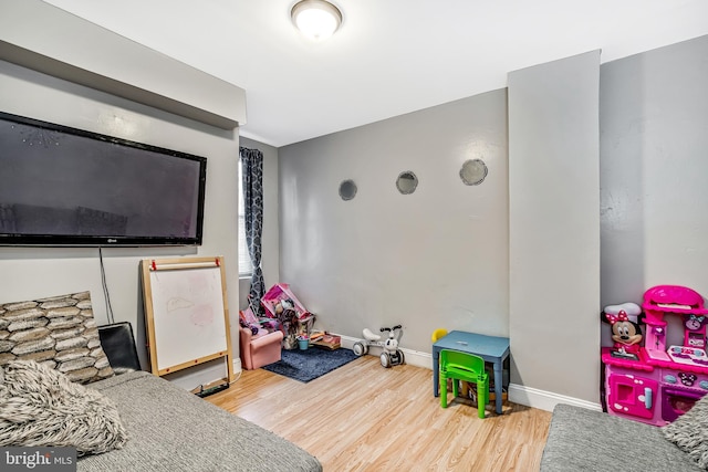 rec room with baseboards and wood finished floors