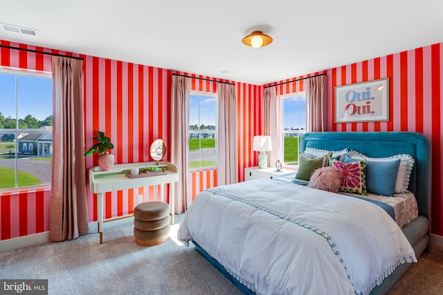 bedroom with carpet floors, wallpapered walls, and visible vents