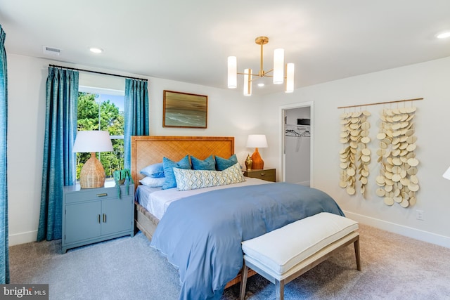 bedroom featuring a walk in closet, visible vents, an inviting chandelier, carpet flooring, and baseboards