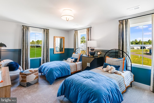 carpeted bedroom with a wainscoted wall and visible vents