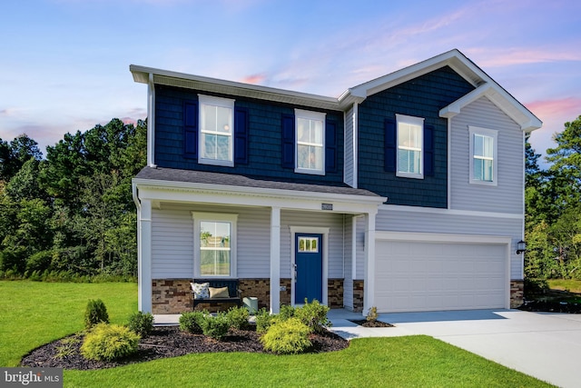 view of front of property with a garage, concrete driveway, stone siding, a porch, and a front yard