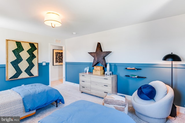 carpeted bedroom with wainscoting and visible vents