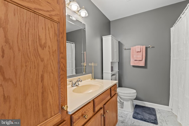 bathroom featuring toilet, marble finish floor, baseboards, and vanity