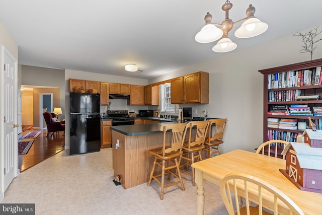 kitchen with brown cabinets, dark countertops, a sink, a peninsula, and black appliances