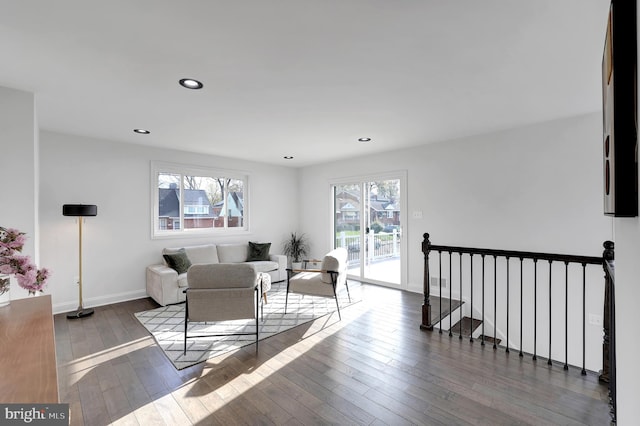 living area with recessed lighting, wood-type flooring, and baseboards