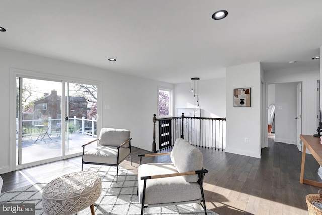 living area with baseboards, hardwood / wood-style floors, recessed lighting, and a healthy amount of sunlight