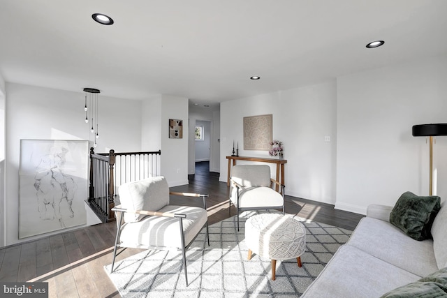 living area with baseboards, wood finished floors, and recessed lighting