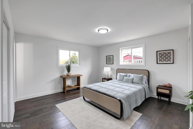 bedroom with dark wood-style flooring, multiple windows, and baseboards