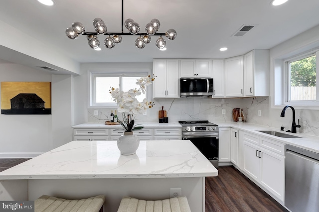 kitchen featuring tasteful backsplash, visible vents, appliances with stainless steel finishes, a sink, and plenty of natural light