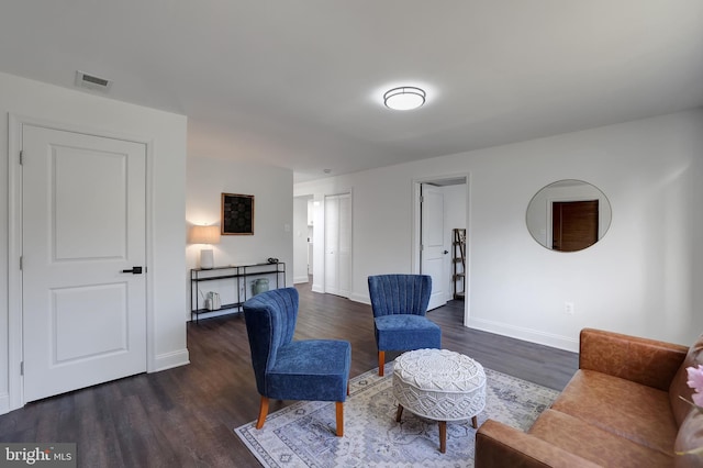 living area featuring dark wood-style floors, baseboards, and visible vents