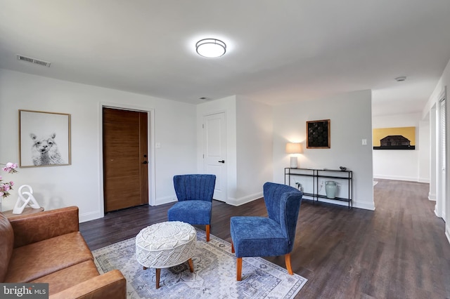 living room with visible vents, baseboards, and wood finished floors