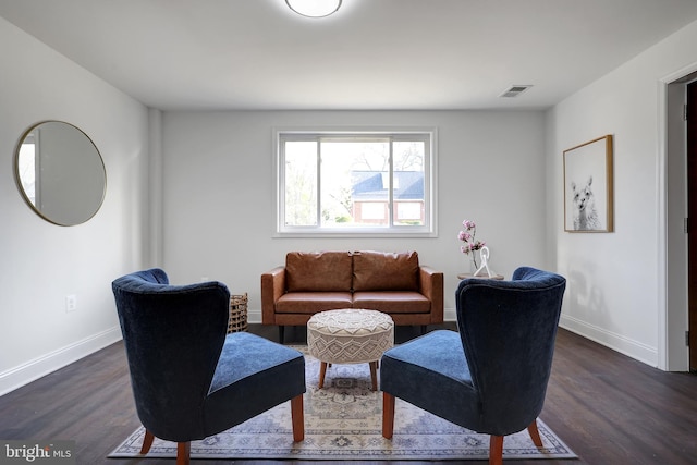 living room featuring dark wood-style floors, visible vents, and baseboards