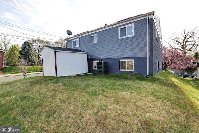 rear view of property featuring central AC and a yard