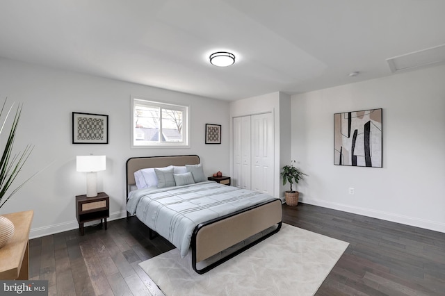 bedroom with attic access, a closet, dark wood finished floors, and baseboards