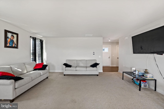 carpeted living room featuring visible vents, plenty of natural light, and baseboards