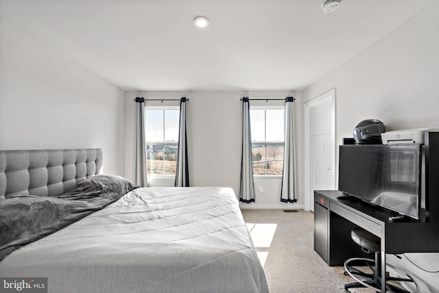 bedroom featuring light carpet, visible vents, and baseboards