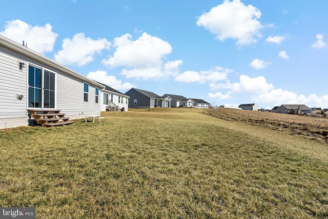 view of yard featuring entry steps and a residential view