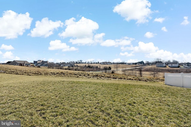 view of yard with fence and a rural view