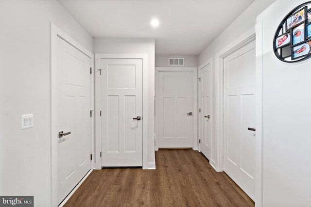 hallway with wood finished floors and visible vents