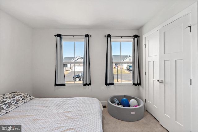 bedroom with carpet, a closet, and baseboards