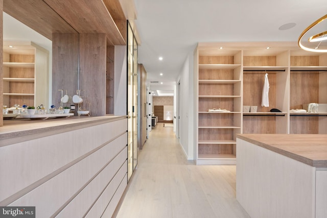 walk in closet with light wood-type flooring