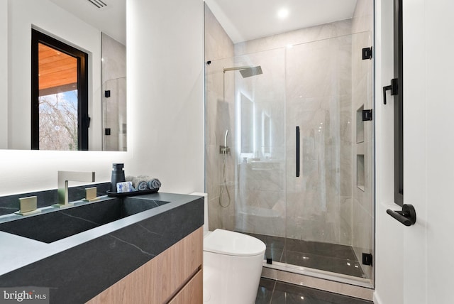 full bathroom featuring toilet, a shower stall, and vanity