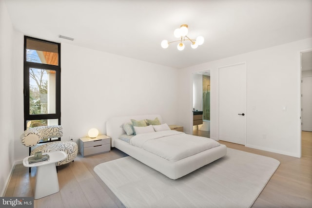 bedroom with visible vents, light wood-style flooring, baseboards, and an inviting chandelier