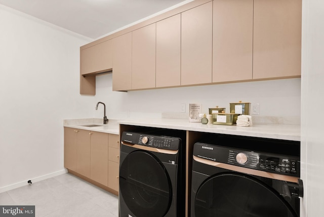 laundry room with cabinet space, baseboards, separate washer and dryer, and a sink